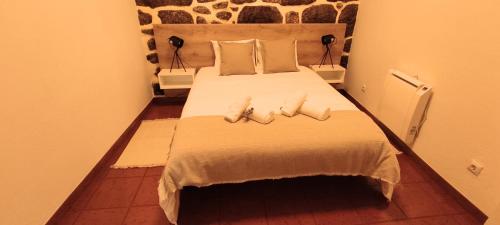 a bedroom with a large bed with two pillows at Recanto da Neta in Seia