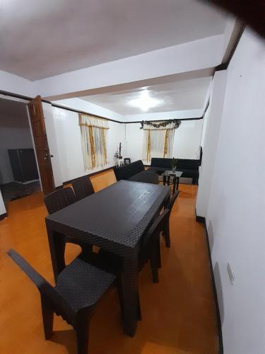 een eetkamer met een zwarte tafel en stoelen bij MountainFog Transient House in Baguio