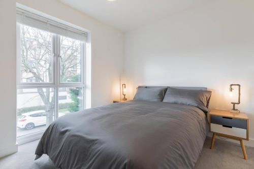 Un dormitorio blanco con una cama grande y una ventana en High Tide en Whitstable