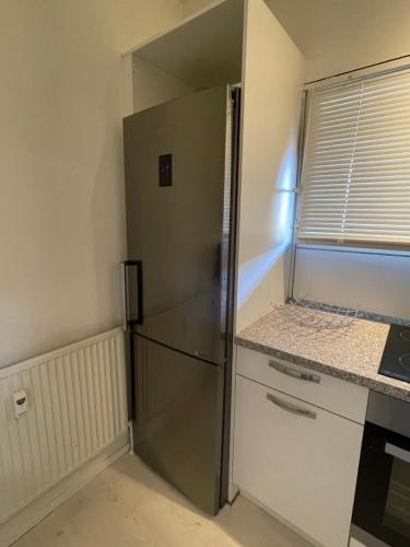 a stainless steel refrigerator in a kitchen next to a window at VS-Guesthouse in Copenhagen
