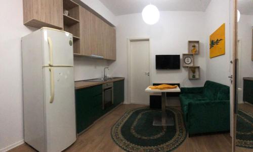 een kleine keuken met een koelkast en een groene bank bij J & A in Tirana