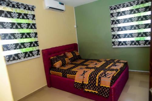 ein Schlafzimmer mit einem Bett in einem Zimmer in der Unterkunft Mena's Home & Apartment in Ughelli