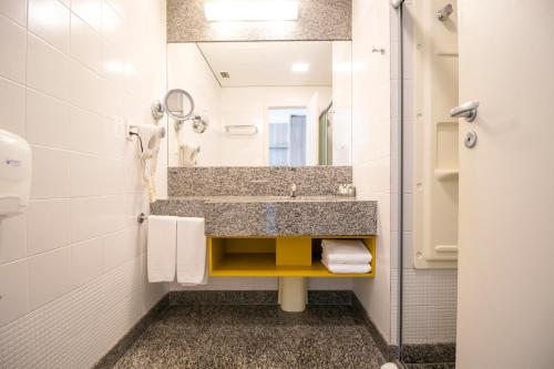 y baño con lavabo y espejo. en Bourbon Belo Horizonte Savassi, en Belo Horizonte
