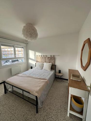 une chambre avec un lit et un miroir dans l'établissement Ravissant T2 en entrée de ville climatisation et parking gratuit, à Ajaccio