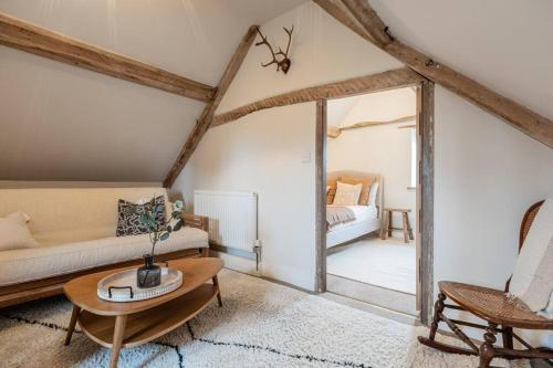 un soggiorno con divano e tavolo di The Gamekeeper's Cottage - Stunning 2 Bed! a Leafield