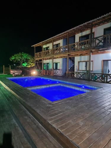 uma villa com piscina à noite em Via Del Mare Flats em Marau