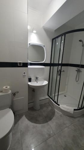 a bathroom with a shower and a sink and a toilet at Hotel Zbyszko in Szczecin