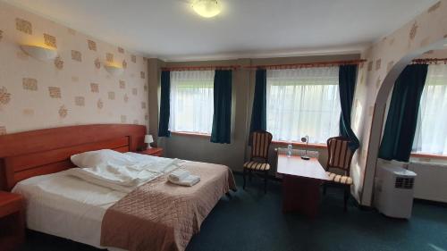 sypialnia z łóżkiem, stołem i krzesłami w obiekcie Hotel Zbyszko w Szczecinie