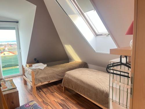 バラトンフレドにあるBalatonfüred Apartmentの屋根裏のベッドルーム(ベッド2台、窓付)