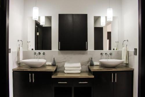 two sinks in a bathroom with two mirrors at New Built Condo minutes to Beach! in Puerto Peñasco