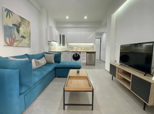 a living room with a blue couch and a kitchen at Burak in Kallithea Rhodes