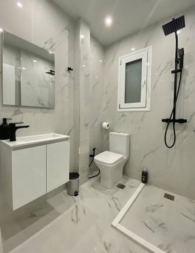 a white bathroom with a sink and a toilet at Burak in Kallithea Rhodes