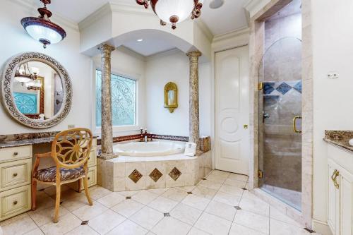 een badkamer met een bad, een wastafel en een spiegel bij Casa Isla Paraiso in Destin