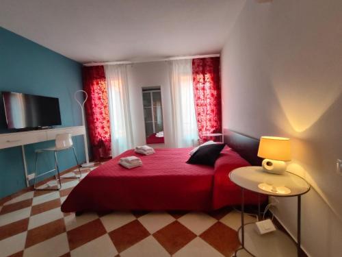 een slaapkamer met een rood bed en rode gordijnen bij San Marco Ca' Tiepolo in Venetië