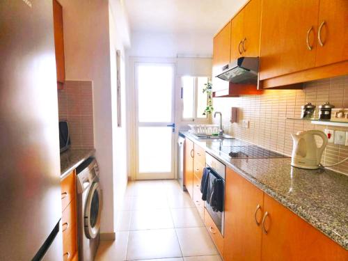 a kitchen with a sink and a stove top oven at Elysia Park - Sea View Deluxe in Paphos City