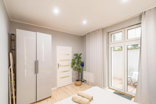 um quarto branco com uma cama e uma janela em Starowiślna Apartment - Balcony, Top Location, Tram & Train Nearby - by Rentujemy em Cracóvia