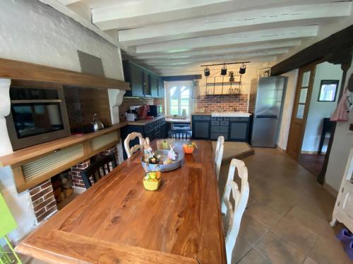 une grande cuisine avec une table et des chaises en bois dans l'établissement Ma Petite Maison dans la Prairie 25 minutes Zoo Beauval, à Gehée