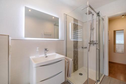een witte badkamer met een wastafel en een douche bij Elversberg in Spiesen-Elversberg