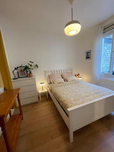 une chambre avec un lit blanc et une fenêtre dans l'établissement Appartement aux Chartrons, à Bordeaux