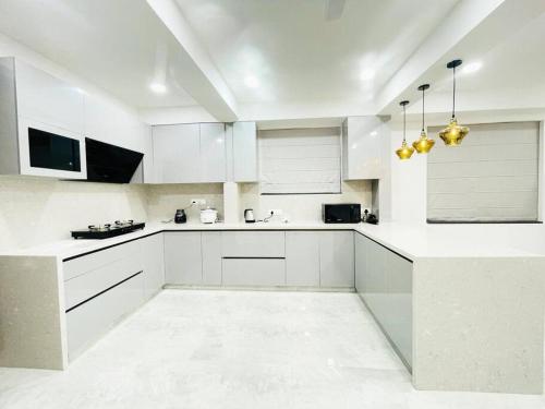a white kitchen with white counters and white cabinets at Dream Pent House in Hyderabad