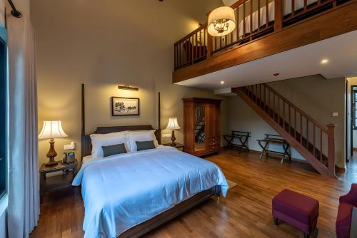 a bedroom with a large bed and a staircase at Chimneys Nuwara Eliya in Nuwara Eliya