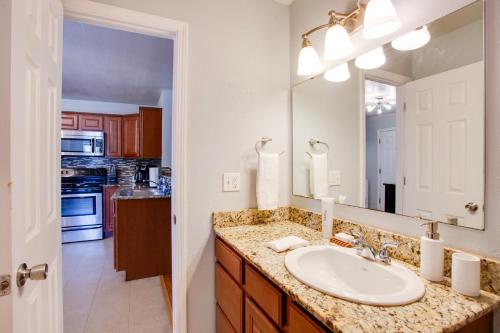 a bathroom with a sink and a mirror at Walkable OSU Apartment - 6 Blocks to Stadium! in Stillwater