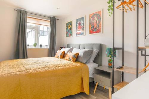 a bedroom with a bed with a yellow bedspread at Little Bright House in Whitstable