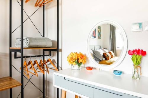 a bathroom with a white counter and a mirror at Little Bright House in Whitstable