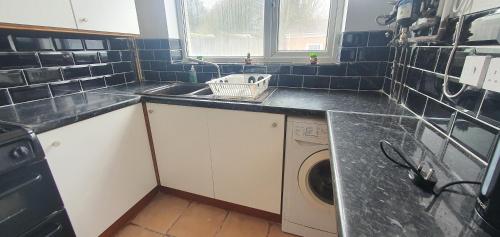 a kitchen with a sink and a washing machine at Beresford House in Longford