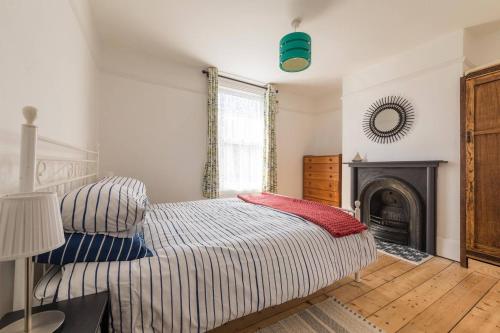 a bedroom with a bed and a fireplace at Painter Cottage in Whitstable
