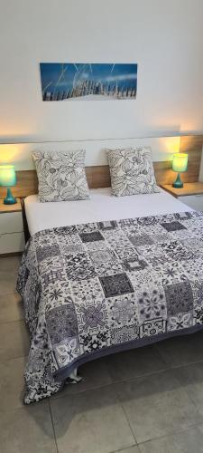 a bedroom with a bed with a quilt on it at Maison Sabline 3 - T2 avec terrasse et parking 700m de l'océan - bébé bienvenu in Yves