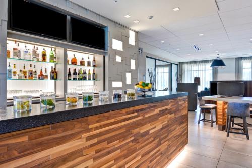 a bar in a restaurant with a counter and chairs at Courtyard by Marriott Jackson Madison in Madison