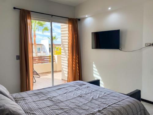 1 dormitorio con 1 cama y TV de pantalla plana en New Built Condo minutes to Beach! en Puerto Peñasco