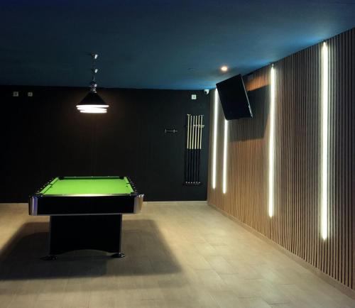 a dark room with a pool table and a television at Hotel Porto in Gandía