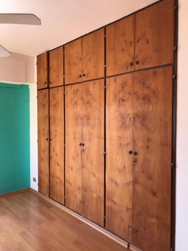 uma parede de portas de madeira num quarto com piso de madeira em Alojamiento por día/mes/año femenino Mafalda Viedma em Viedma
