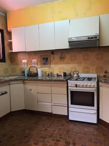 uma cozinha com armários brancos e um fogão em Alojamiento por día/mes/año femenino Mafalda Viedma em Viedma