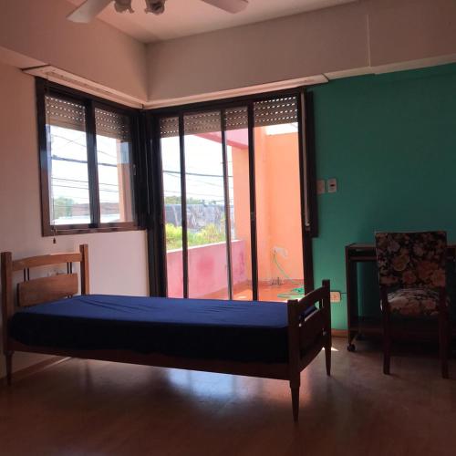 um quarto com uma cama num quarto com janelas em Alojamiento por día/mes/año femenino Mafalda Viedma em Viedma
