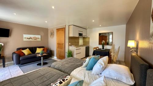 a living room with two beds and a kitchen at La Maison Blanche in Sangatte