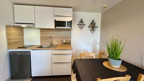 a small kitchen and dining room with a table at La Maison Blanche in Sangatte