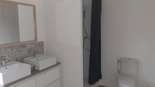 een badkamer met 2 wastafels en een toilet bij Les Terrasses du Verger in Monistrol-dʼAllier