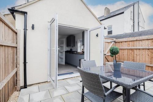 a patio with a table and chairs and a kitchen at Stylish 2 Bed with Free Private Parking! in Cheltenham