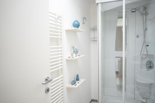 La salle de bains est pourvue d'une douche et d'une cabine de douche en verre. dans l'établissement l'Apostolo e il Navarca, à Ortona