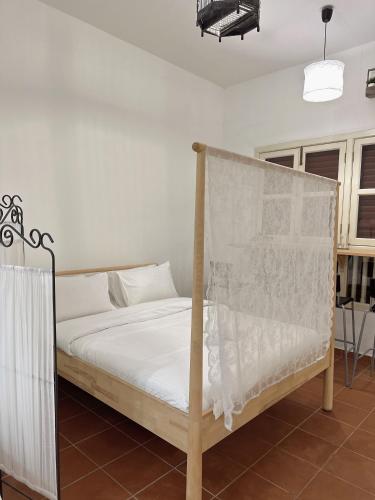 1 dormitorio con 1 cama con edredón blanco en The Garden Suit en George Town