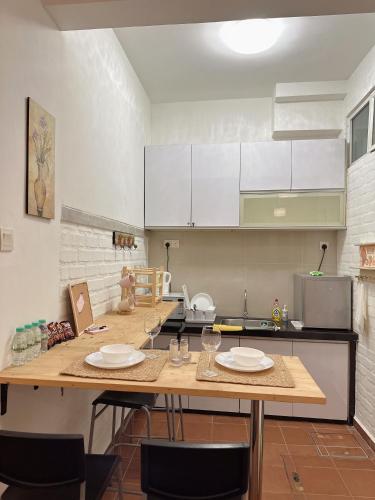 a kitchen with two tables with chairs and white cabinets at The Garden Suit in George Town