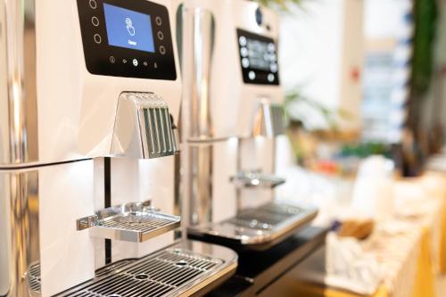 une machine à café assise au-dessus d'un comptoir dans l'établissement Hotel Delaville Frontemare, à Lido di Jesolo