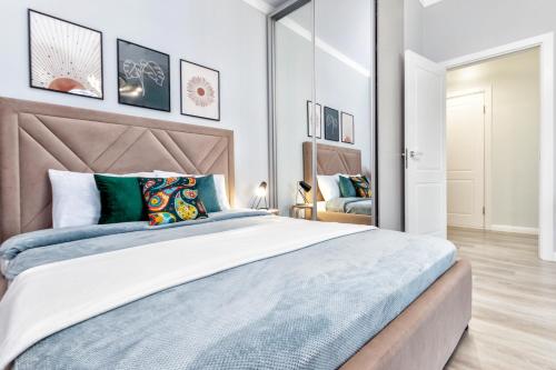 een slaapkamer met een groot bed met een groot hoofdeinde bij Grand Turan Business One-Room Apartments in Astana