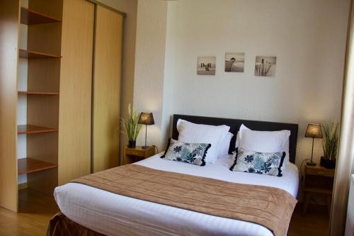 a bedroom with a large bed with two pillows at La Maison Blanche in Sangatte