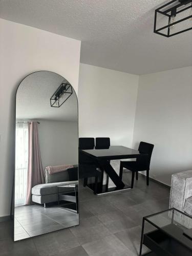 - un salon avec une table et un miroir dans l'établissement Appartement face stade de france, à Saint-Denis