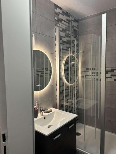une salle de bain avec un lavabo et une douche dans l'établissement Appartement face stade de france, à Saint-Denis