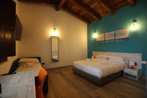 ジッツェリーアにあるCasale Calabriaのベッド2台とテーブルが備わるホテルルームです。